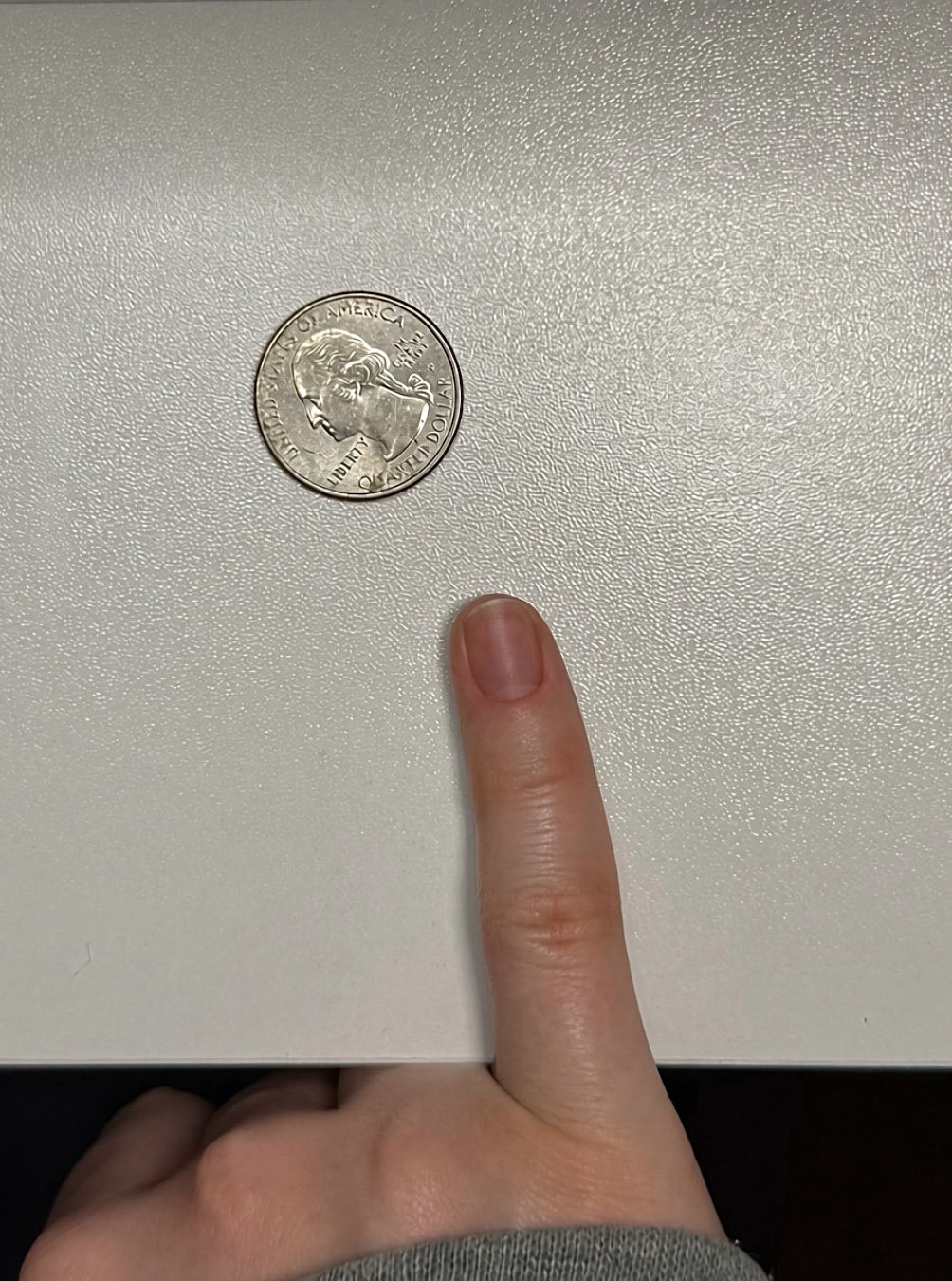 Example sizing photo showing a pinky nail beside a quarter